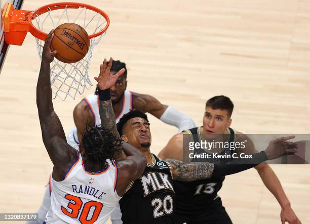 John Collins of the Atlanta Hawks is elbowed in the face as Julius Randle of the New York Knicks attacks the basket in the second half during game...
