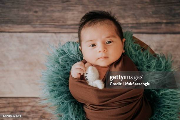 little baby boy with knitted hat in a basket, happily smiling and looking at camera, isolated studio shot - baby blue eyes stock pictures, royalty-free photos & images