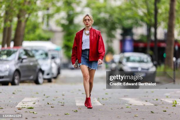 Emy Venturini wears Prada sunglasses, gold earrings, a red shiny leather oversized vintage jacket, a gold large chain necklace, a white T-shirt from...