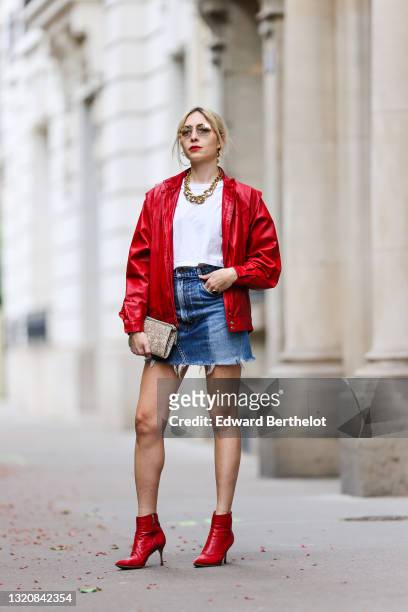 Emy Venturini wears Prada sunglasses, gold earrings, a red shiny leather oversized vintage jacket, a gold large chain necklace, a white T-shirt from...