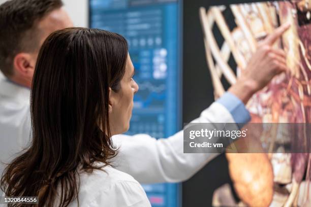 ärzte diskutieren auf einem großen touchscreen mit 3d-modell des menschlichen körpers internals. - human internal organs 3d model stock-fotos und bilder