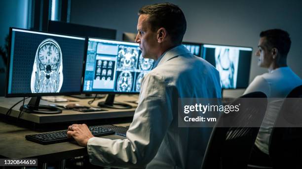 profissionais médicos examinando exames de ressonância magnética. - ultrasonografia médica equipamento de monitoramento - fotografias e filmes do acervo