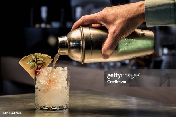 preparazione di un cocktail gustoso, utilizzando uno shaker. - cocktail foto e immagini stock