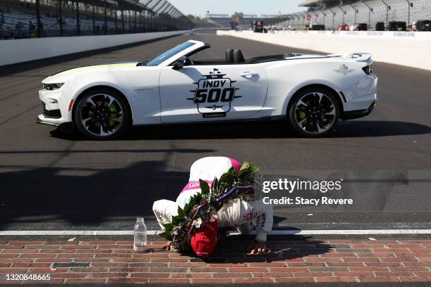 Helio Castroneves of Brazil, driver of the AutoNation/SiriusXM Meyer Shank Racing Honda, celebrates by kissing the yard of bricks after winning the...