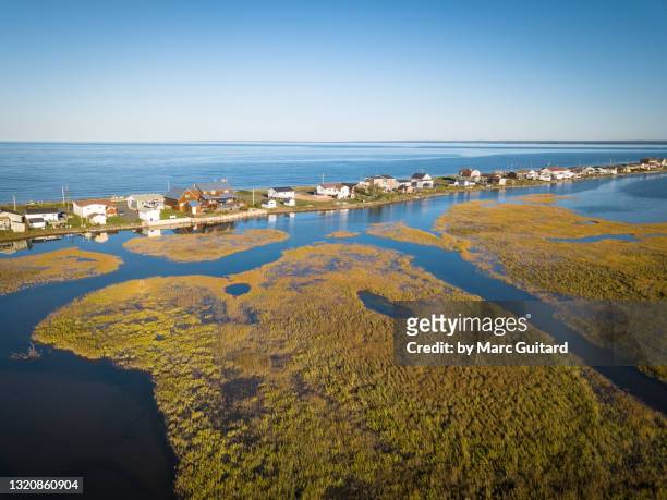 cottages along a sandbar backed by salt marshes. beresford, new brunswick, canada - tidal marsh stock pictures, royalty-free photos & images