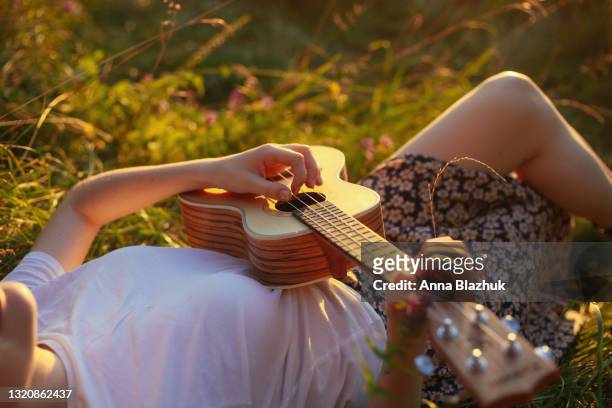 summer natural portrait of young relaxed woman outdoors. picnic and relax and leisure activity concept. green public park background. - ukulele stock-fotos und bilder