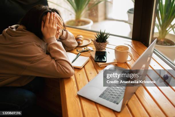 young woman tiered and using lap top in cafe. - smart glasses stockfoto's en -beelden