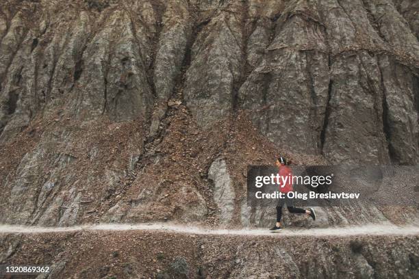 woman running in rocky mountains by trail footpath. active and healthy lifestyle - calze di nylon foto e immagini stock