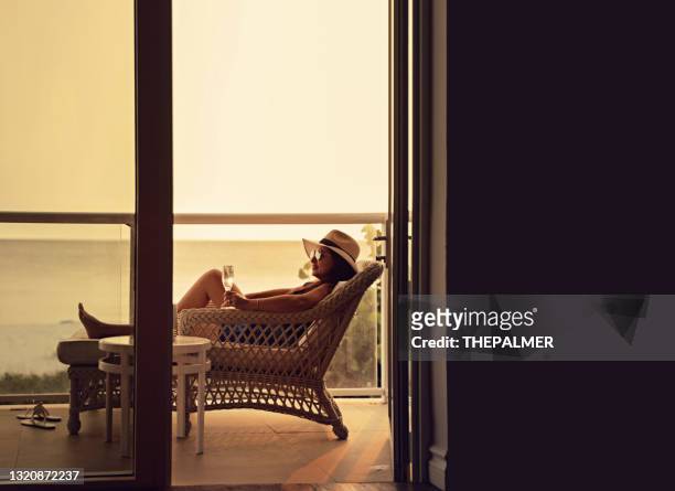 latin woman having a glass of wine in a balcony in florida - beach balcony stock pictures, royalty-free photos & images