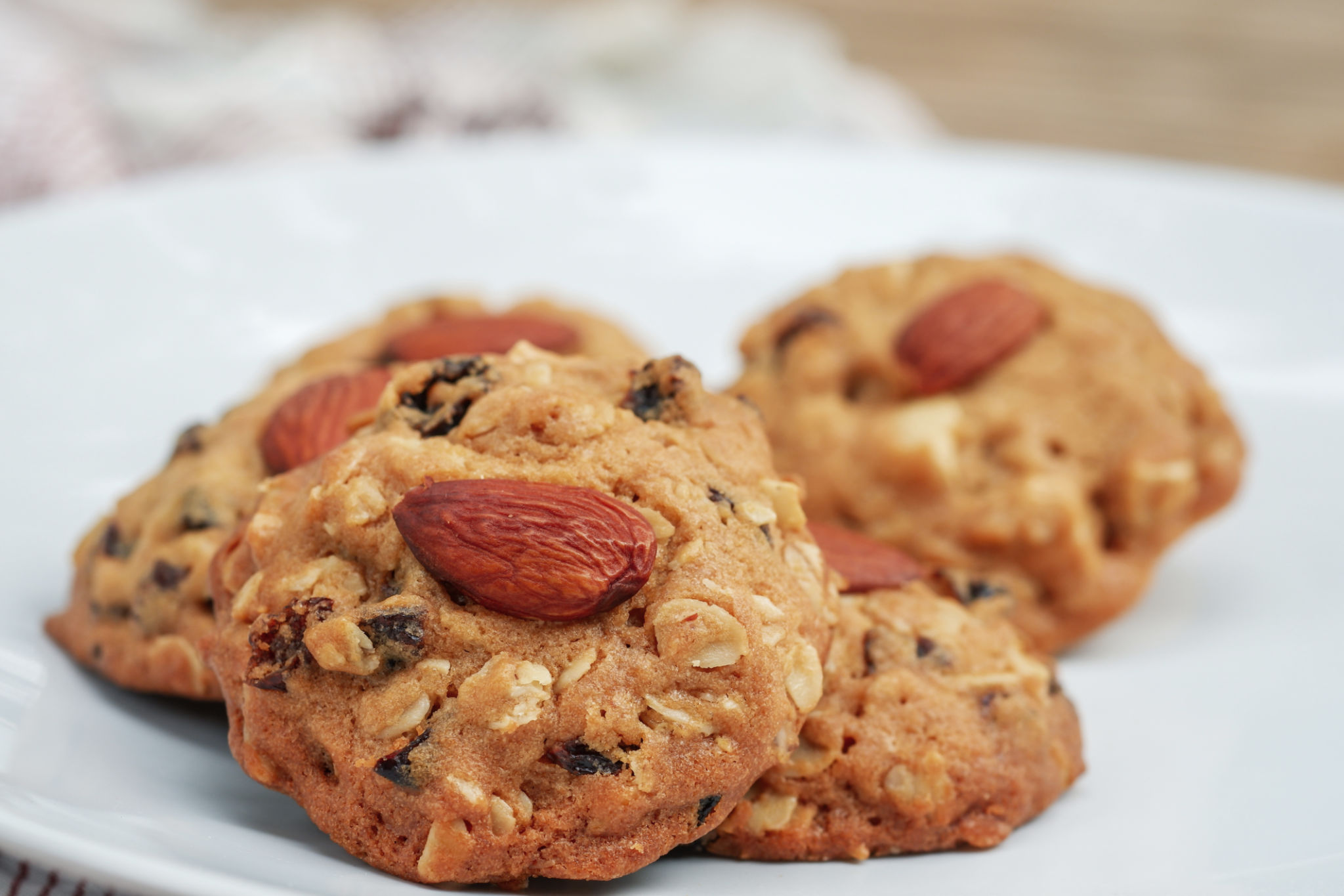 Closeup Almond cookies or healthy snacks stack on a white plate with a blurred background. Closeup Almond cookies or healthy snacks stack on a white plate with a blurred background.