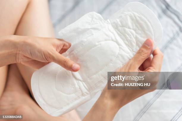 closeup of woman hands holding white sanitary pad - menstruation menschliche körpersubstanz stock-fotos und bilder