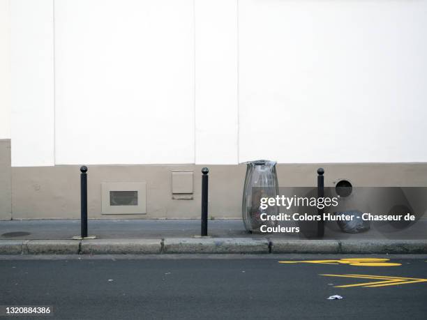 plastic garbage bags on a parisian street and white wall - trottoir paris stock-fotos und bilder