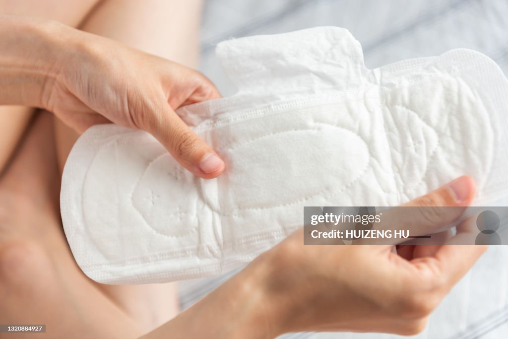 Closeup of woman hands holding white sanitary pad