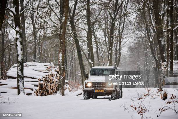 land rover defender nella neve - land rover foto e immagini stock