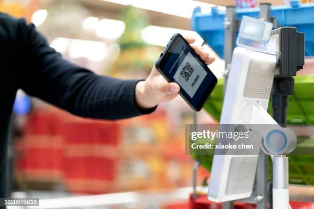 verwenden sie den scancode für mobiltelefone, um zu bezahlen - paying supermarket stock-fotos und bilder