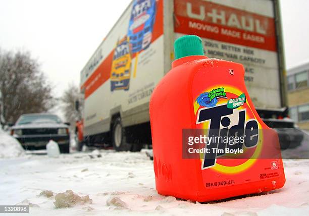 Large U-Haul truck threads through a Chicago street December 20, 2000 as an empty plastic bottle of Tide laundry detergent protects a resident''s...
