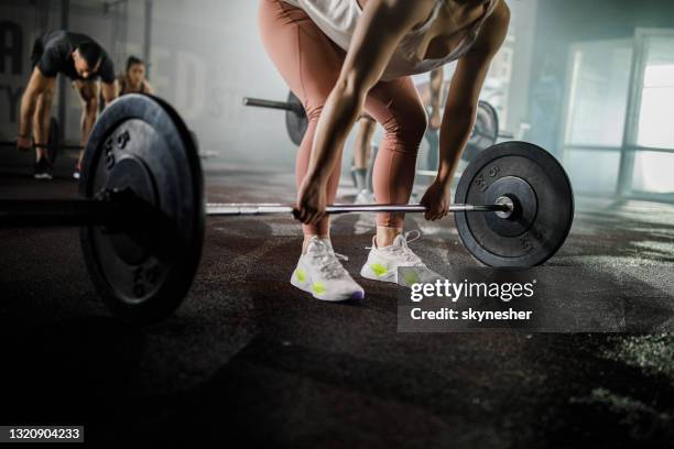 atleta femenina irreconocible haciendo ejercicio con barra en un gimnasio. - levantamiento-de-potencia fotografías e imágenes de stock