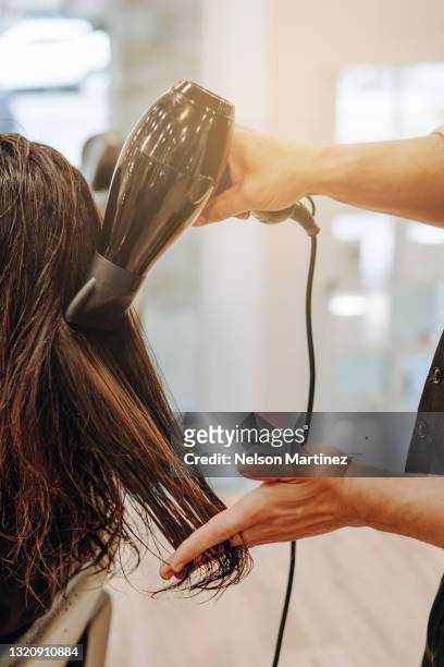 professional hairdresser drying woman's hair at the hairdressing - man combing hair stock pictures, royalty-free photos & images