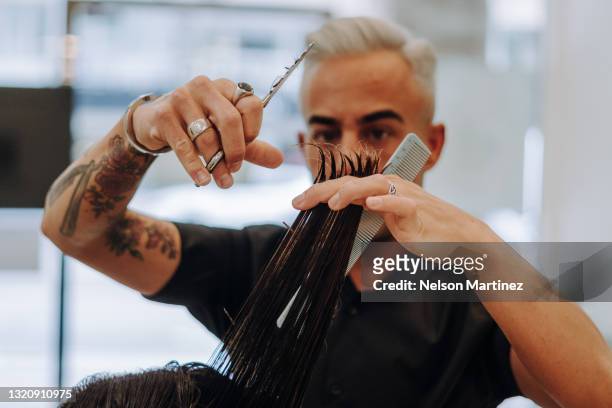 a handsome hairstylist working at the hairdressing - at hairdresser stock-fotos und bilder