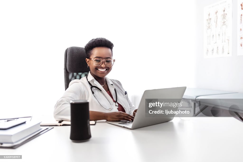 Femme assise au bureau du médecin à l’aide de l’assistant virtuel au bureau