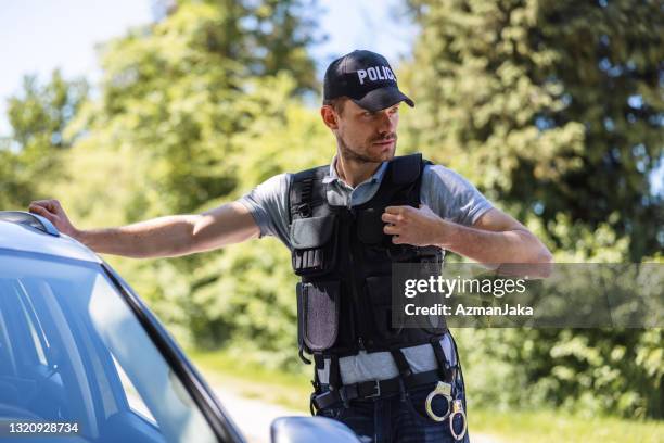 police officer talking on walkie talkie and stopping a speeding car - slovenia police stock pictures, royalty-free photos & images