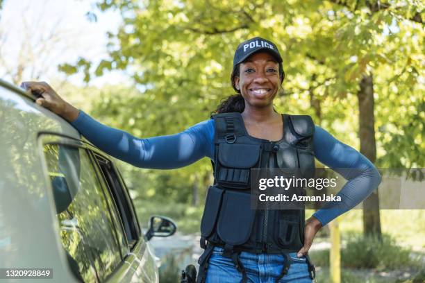 policewoman standing next to car and smiling at camera - slovenia police stock pictures, royalty-free photos & images