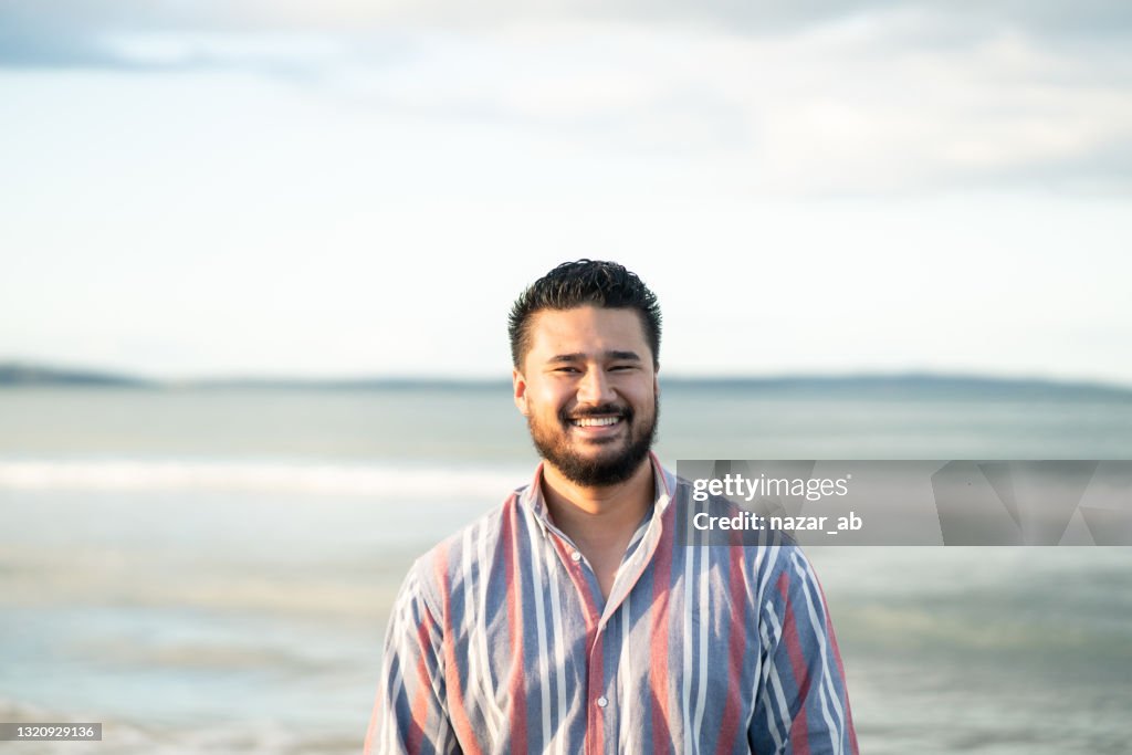 Happy man on beach looking at camera.