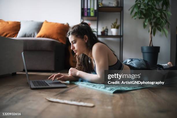 young woman using a laptop while practicing yoga - leggings stock pictures, royalty-free photos & images