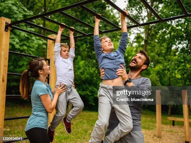 active family time at the outdoor gym - bars playground stock pictures, royalty-free photos & images
