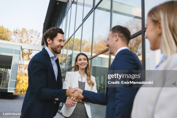 happy male executives meeting and handshaking on the street - close stock pictures, royalty-free photos & images