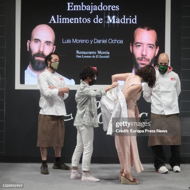 The acting president of the Community of Madrid, Isabel Diaz Ayuso, puts on a jacket during the presentation of Daniel Ochoa and Luis Moreno -chefs...