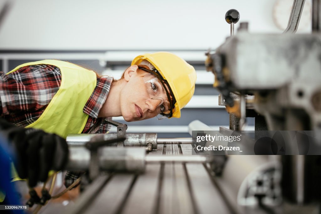 Women with protective equipment working on the drill in factory plant