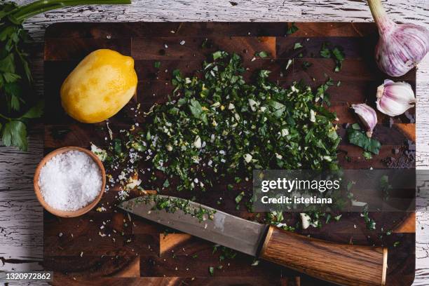 making italian gremolata, ingredients on wooden board, messy situation - chopped herbs stock pictures, royalty-free photos & images
