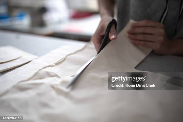 asian chinese female fashion college student cutting lining clothing project at college workshop - atelier fashion stock pictures, royalty-free photos & images