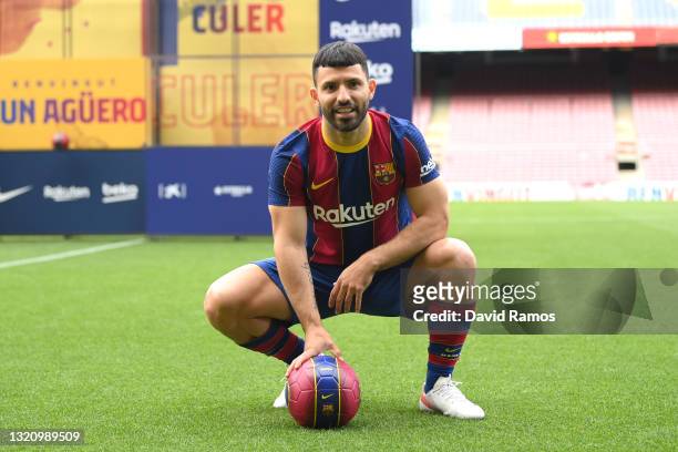 Sergio Aguero reacts whilst posing for a photograph as he is presented as a Barcelona player at the Camp Nou Stadium on May 31, 2021 in Barcelona,...