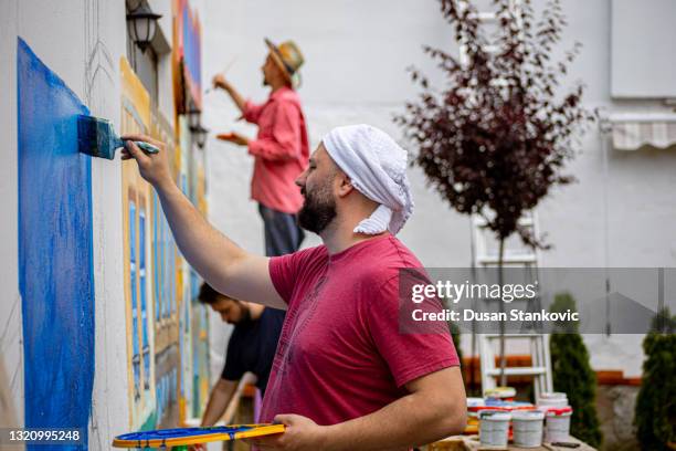 group of artist painting wall mural - painting mural stock pictures, royalty-free photos & images