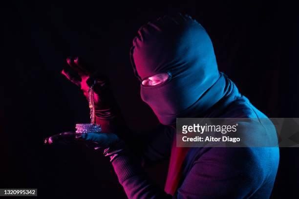 a thief stealing jewellery at night. - spielkarte karo stock-fotos und bilder