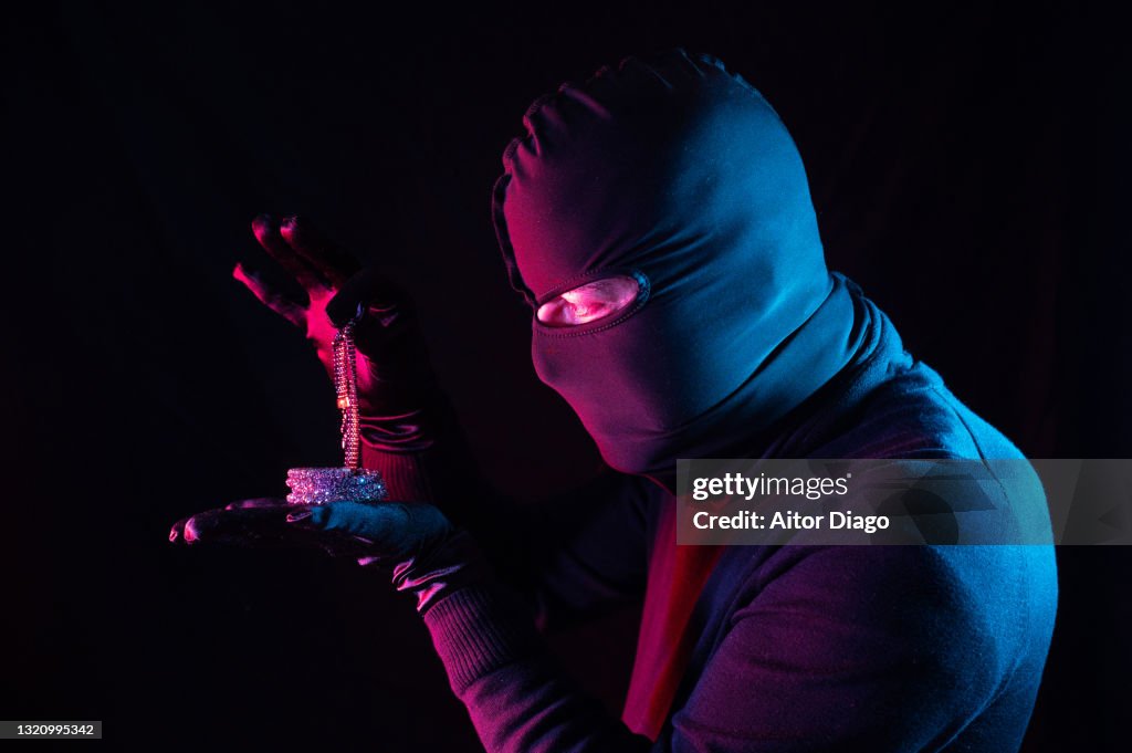 A thief stealing jewellery at night.
