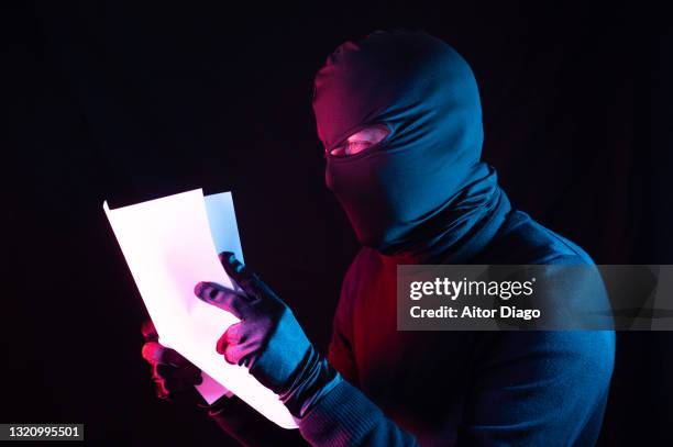 a thief steals some documents. - balaclava gun stock pictures, royalty-free photos & images