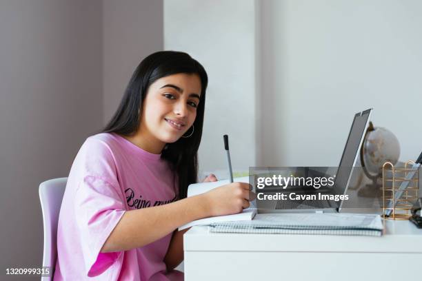 cheerful teenager studying at desk in own room - laptop netbook fotografías e imágenes de stock