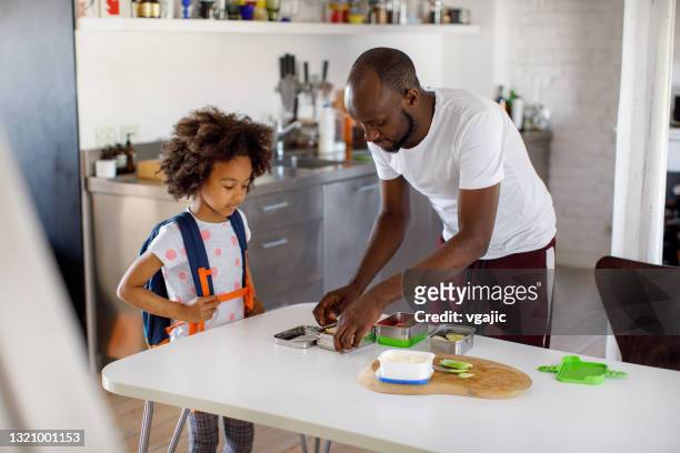 father packing school lunch for his daughter - lunch bag stock pictures, royalty-free photos & images