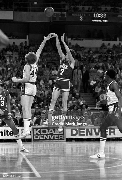 New Orleans Jazz guard Pete Maravich shoots a jump shot over Denver Nuggets center Dan Issel near the free throw line during an NBA basketball game...