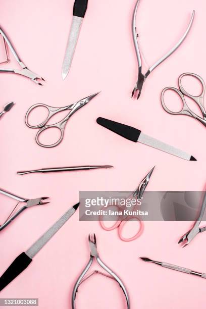 set of manicure tools on trendy pastel pink background. nail files, scissors, cuticle clippers. vertical. - cutícula fotografías e imágenes de stock