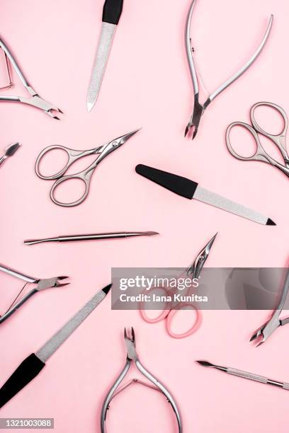 set of manicure tools on trendy pastel pink background. nail files, scissors, cuticle clippers. vertical. - pedicure stockfoto's en -beelden