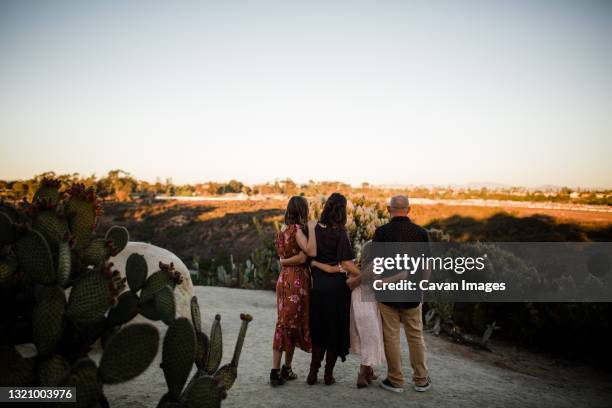 family of four enjoying the view in garden in san diego - balboa park stock pictures, royalty-free photos & images