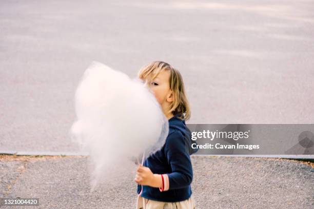 cute young girl 3-4 years old eating cotton candy - turin food stock pictures, royalty-free photos & images