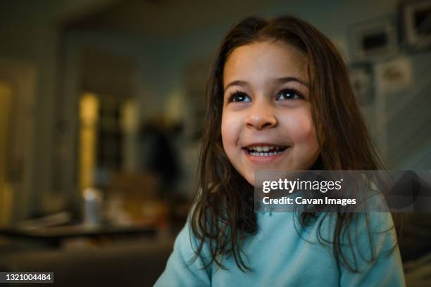 girl age 4 watching tv in the evening, big smile - alleen één meisje stockfoto's en -beelden