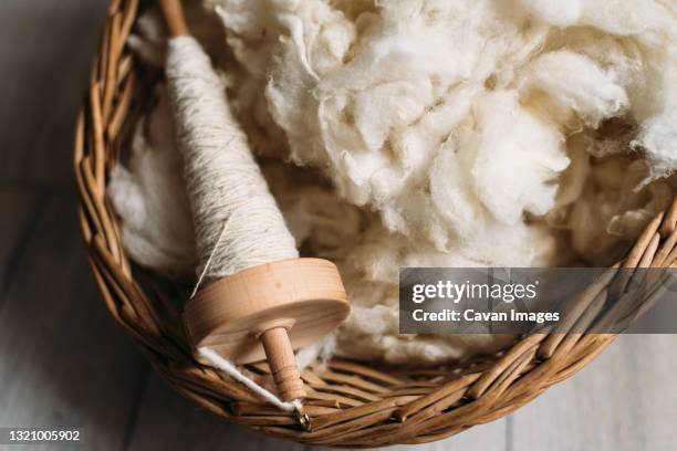 sheep wool and yarn in a wicker basket - wol stockfoto's en -beelden