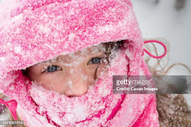 a portrait of a girl dressed for winter covered in snow - winter skin stock pictures, royalty-free photos & images