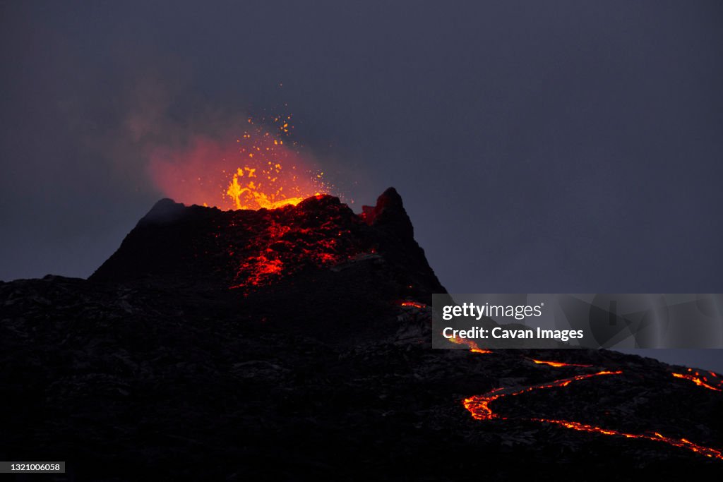 Volcano erupting on background of night sky
